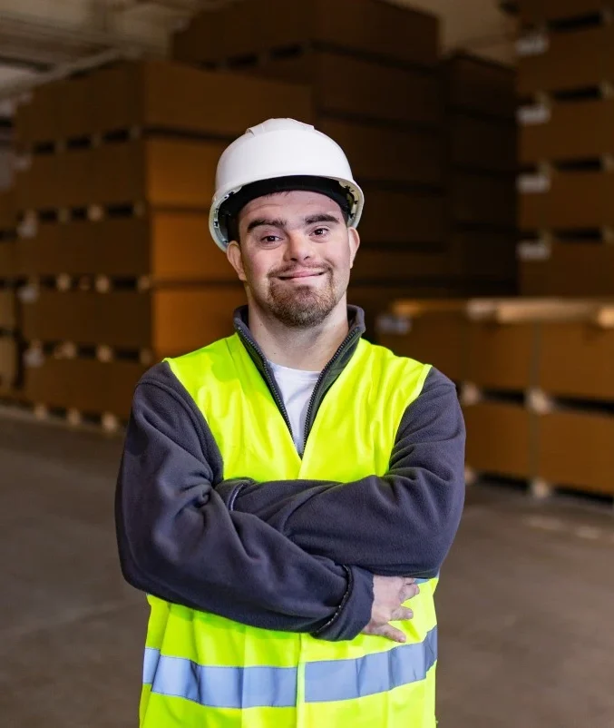 Disabled man with down syndrome at work wearing hi vis vest and helmet